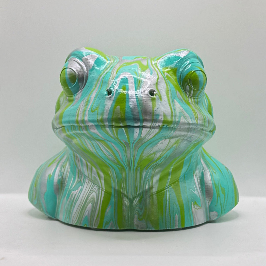 Front view of a hand-painted frog ornament in turquoise, lime green and silver